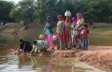 妇女在拉贾斯坦邦从池塘加深的池塘加深的妇女加深了Ambuja水泥基金会